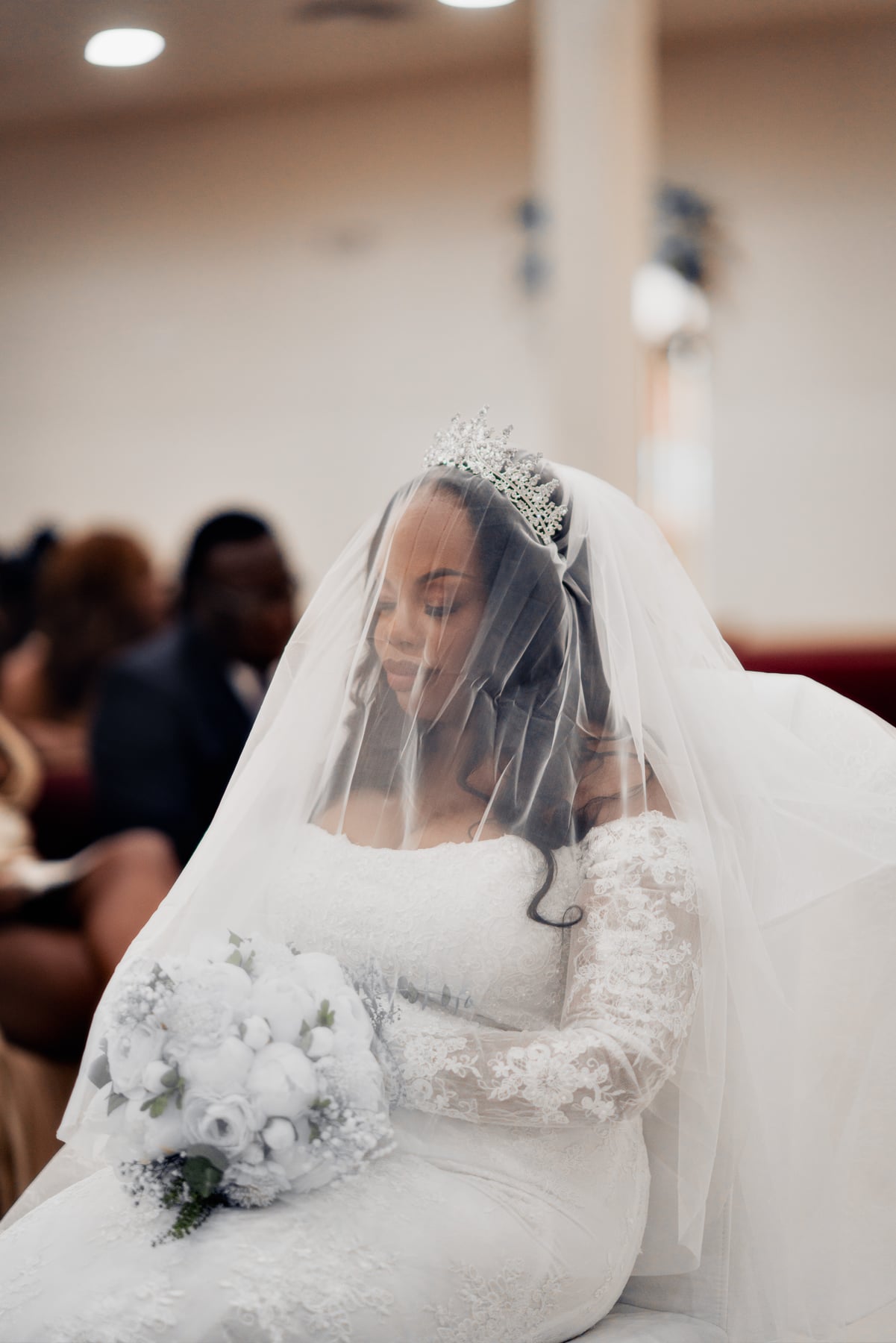 Bride in a veil holding a white bouquet